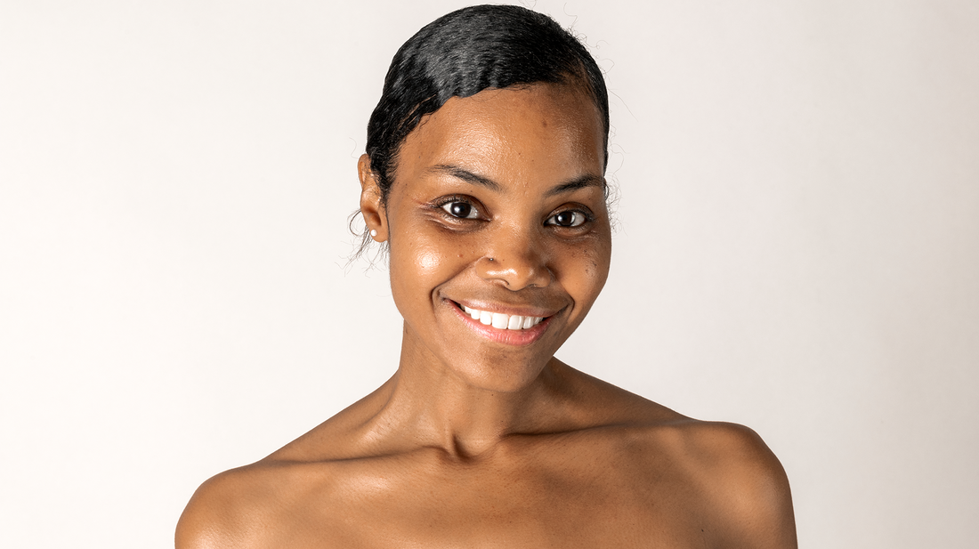 Person with medium-deep skin tone looking at camera against a warm, clean background
